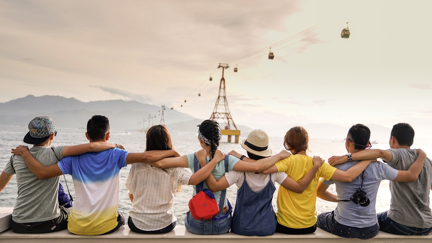 Friends sitting together with arms around each other